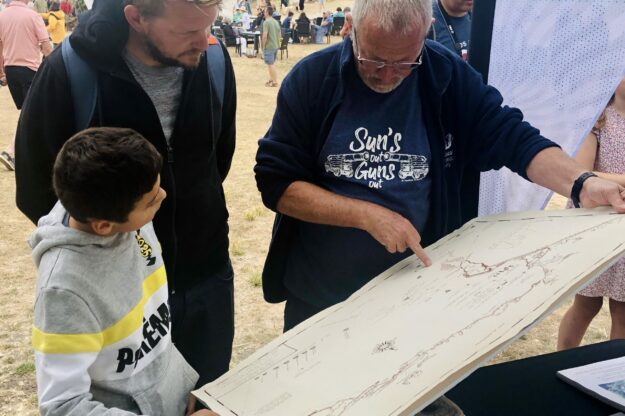 Portland Museum Earl of Abergavenny project volunteer showing a map of the ship's journey to pop up visitors