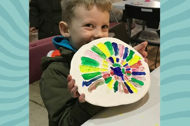 Child showing painted fossil cast