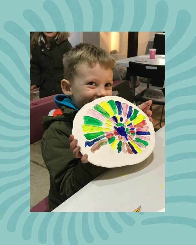 Child showing painted fossil cast